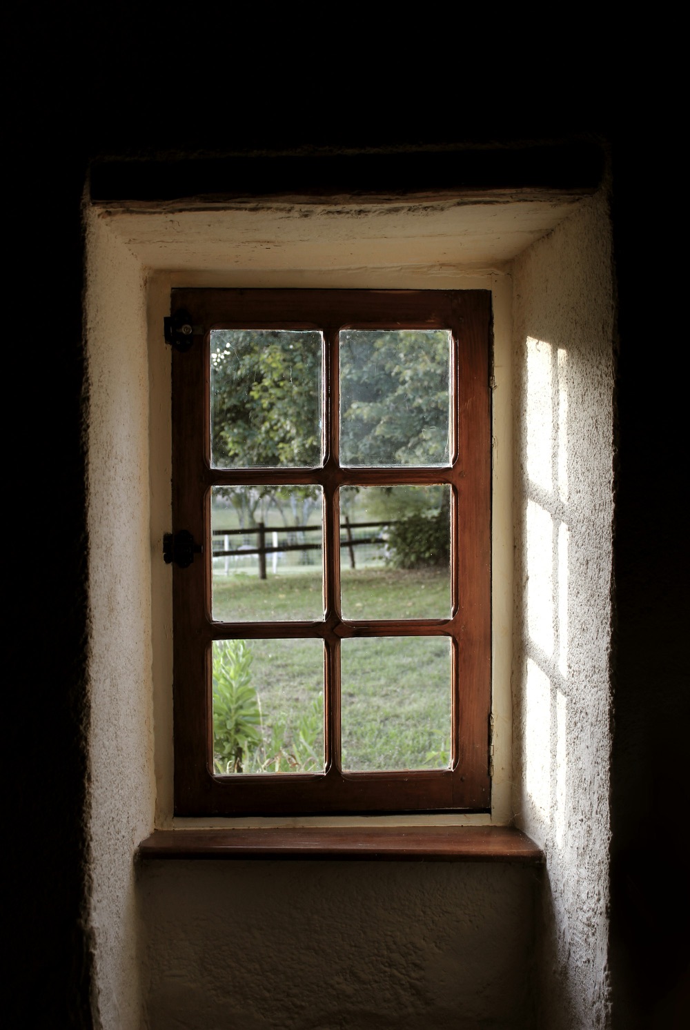 Châssis en bois vu de l'intérieur, ouvert sur un jardin